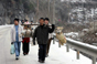 2008年1月26日，重庆市酉阳县的村民在覆盖着积雪的公路上行走。连日来，重庆部分地区降雪，不少道路封闭，一些村民只能步行回家。